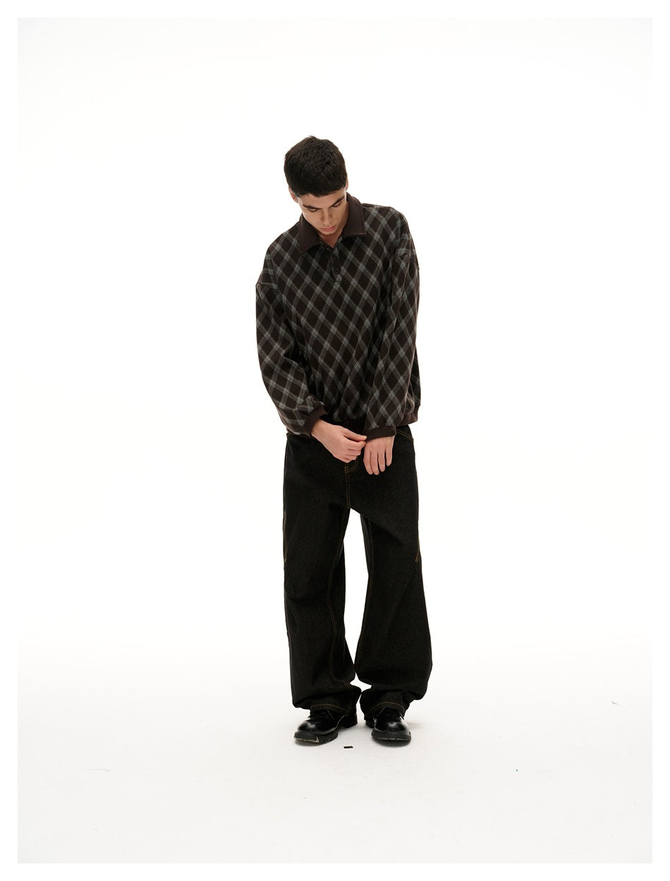 Model looking down while wearing a dark brown and gray diamond-check collared pullover with black wide-leg pants.