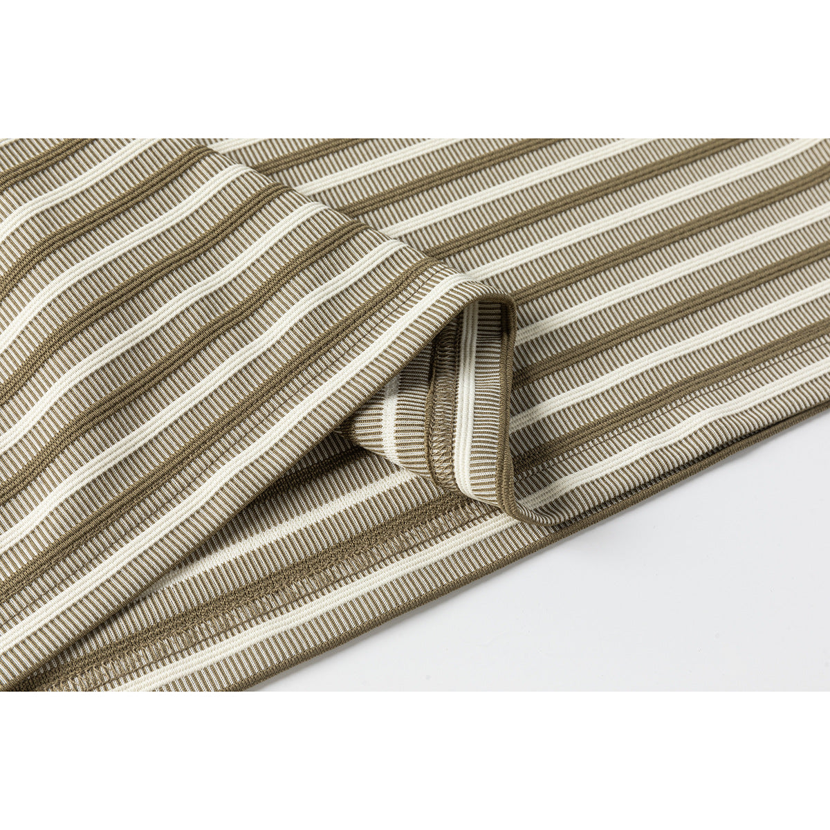 Close-up of the folded hem and textured ivory and brown horizontal stripes on a T-shirt.