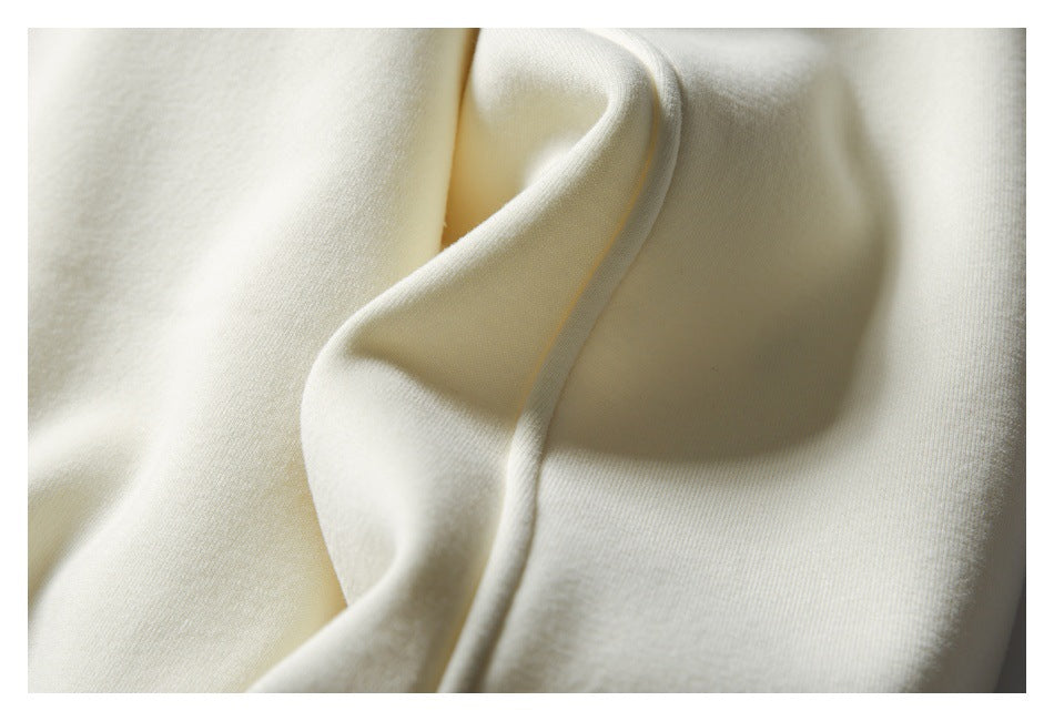 Close-up of ivory fabric with a smooth folded edge and soft shadows.
