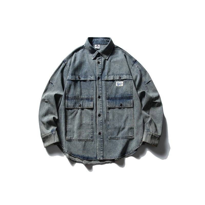 Front view of a faded blue-gray denim shirt jacket with a pointed collar, black buttons, and two large flap pockets.