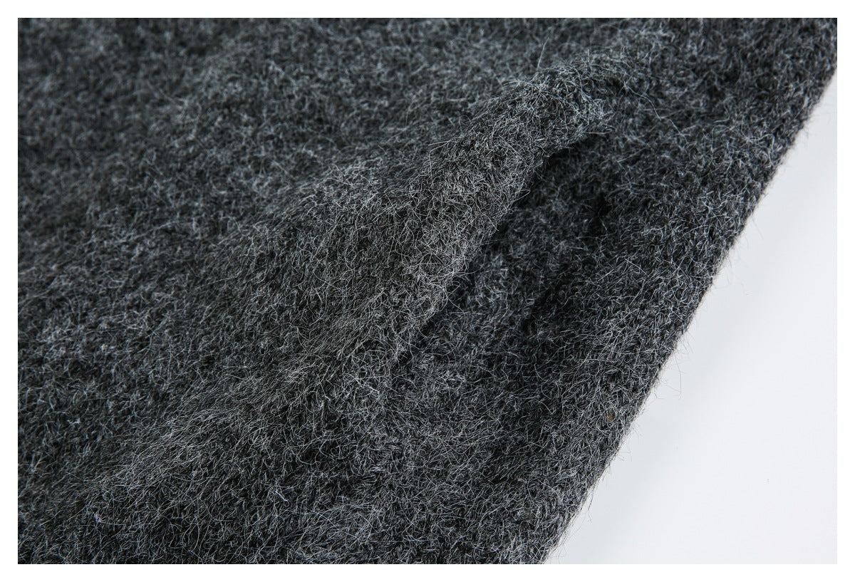 Close-up of a folded seam in charcoal gray fuzzy knit fabric.