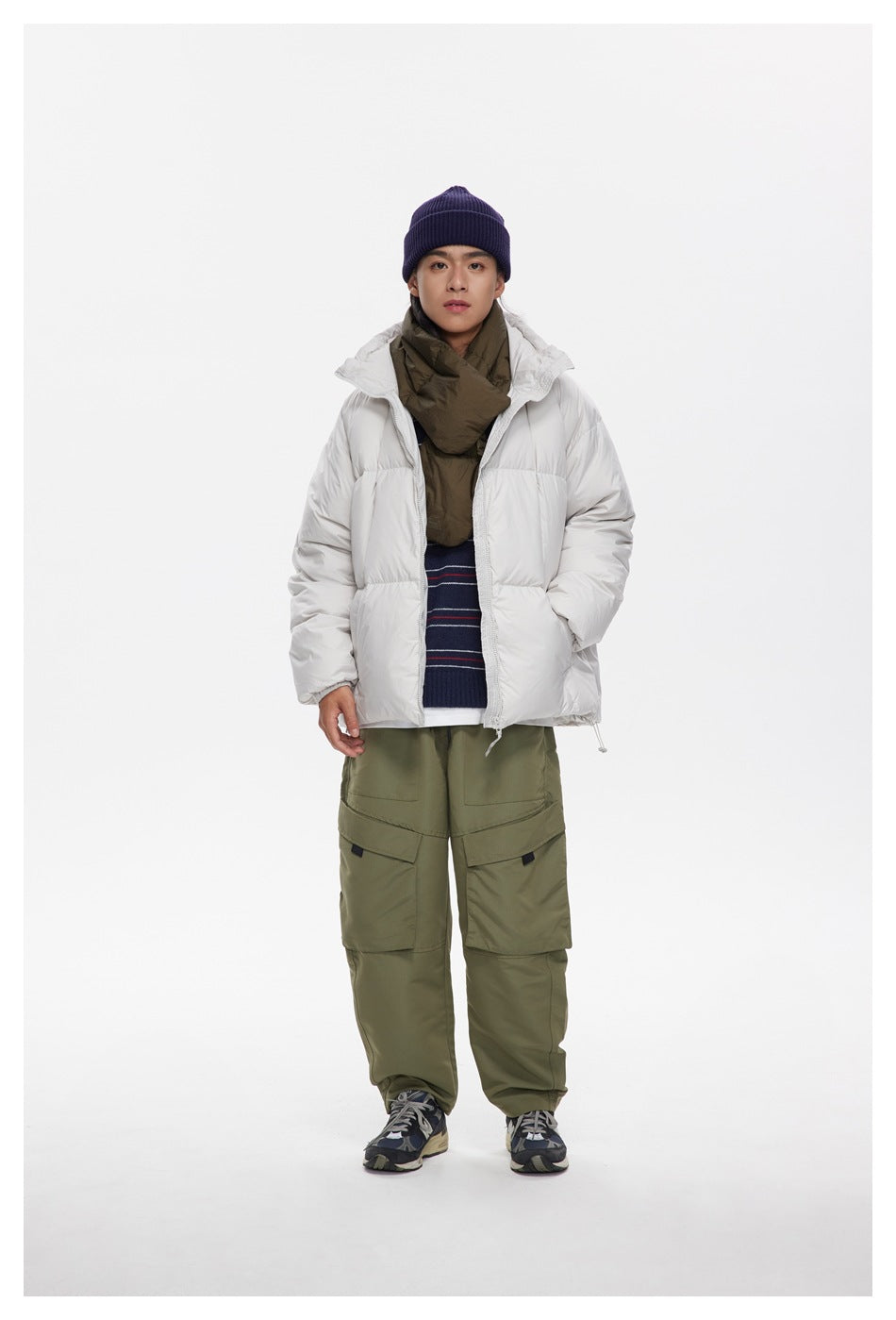 Full-length model wearing an open white hooded puffer jacket over layered clothing and olive cargo pants.