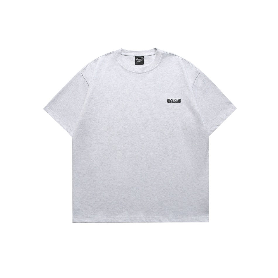 Front of heather gray crew-neck short-sleeve t-shirt with small black chest patch, flat lay