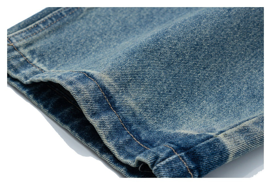 Close-up of the folded hem and leg of blue denim jeans.