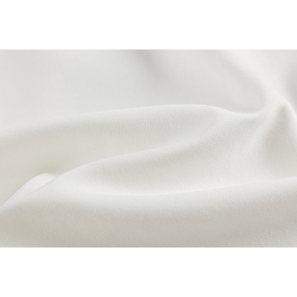 Close-up showing the textured surface and folds of white shirt fabric.