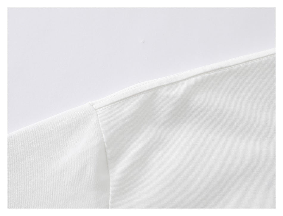 Close-up of the white T-shirt's shoulder seam and stitching.