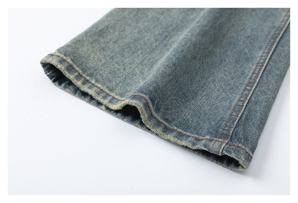 Close-up of the blue denim jeans leg opening, showing the hem and reddish-brown stitching.