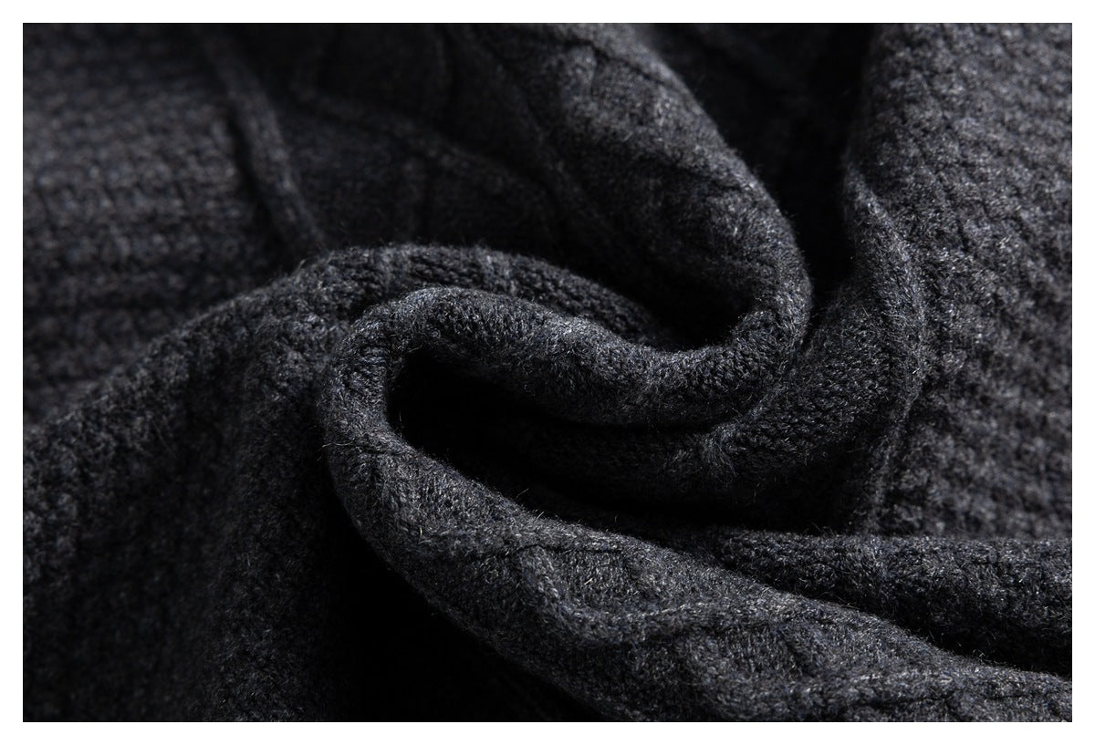 Close-up of charcoal knit fabric folded to show its thick texture and edges.