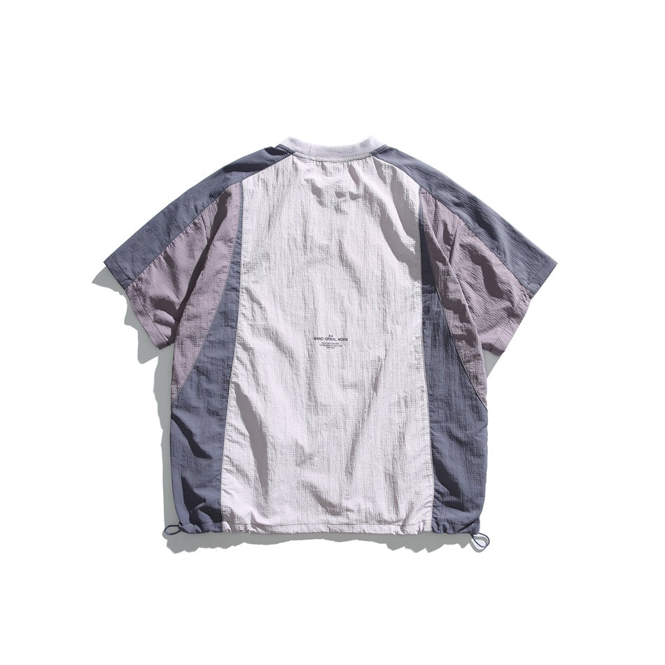 Back view of a lavender and pale gray color-block short-sleeve shirt with a gathered drawcord hem.