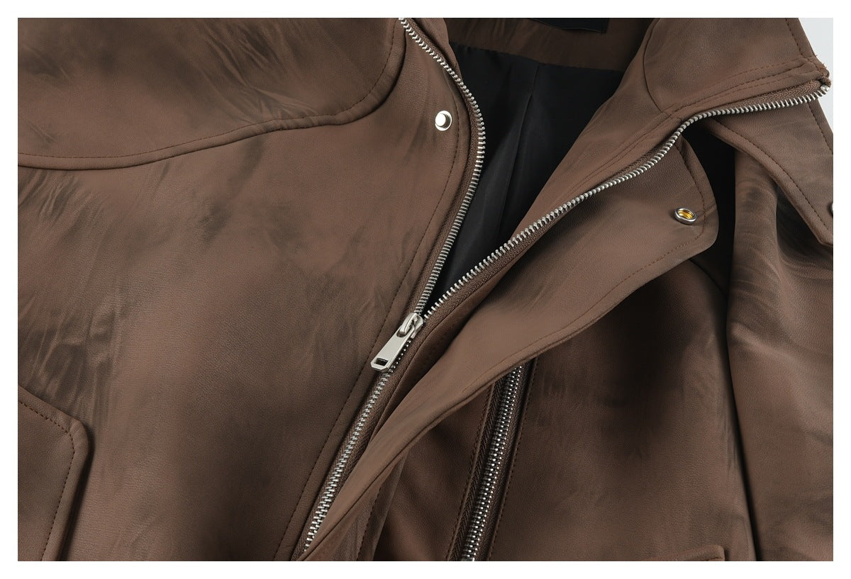 Close-up of a brown jacket showing its metal front zipper, snap fasteners, and overlapping storm flap.