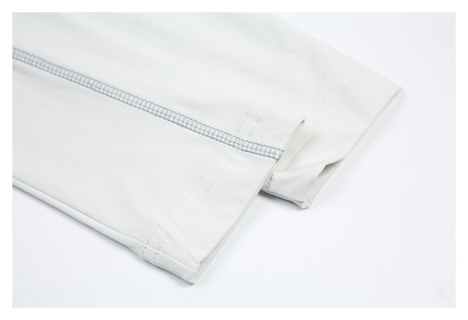 Close-up of a white garment hem with pale blue overlock stitching and parallel seam lines.