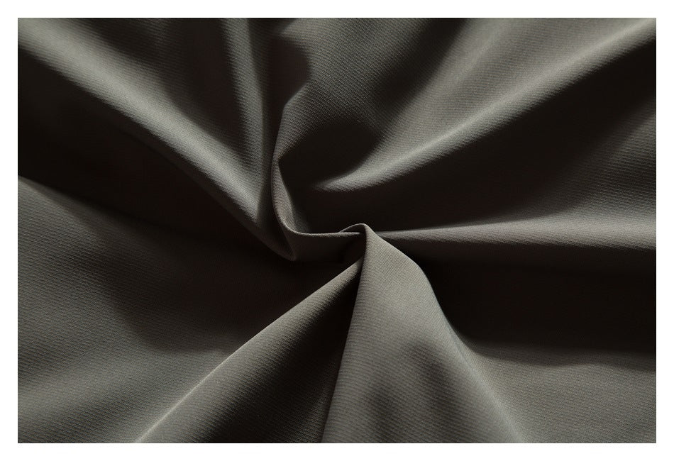Close-up of softly folded dark olive jacket fabric.