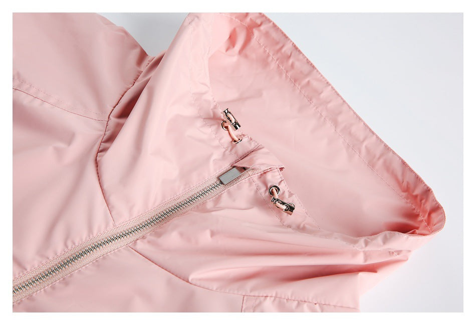 Close-up of a pale pink jacket showing a zipper and metal toggle fasteners near the collar.