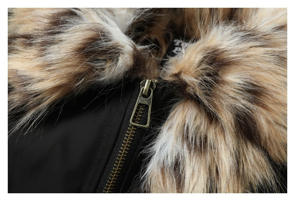Close-up of a black garment with a brass-tone zipper and thick brown, tan, and cream fur trim.