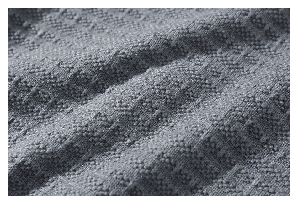 Extreme close-up of the raised, irregular knit texture of gray fabric.
