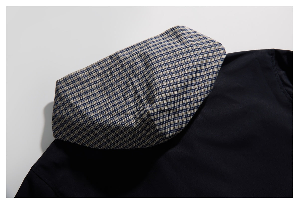 Close-up of a dark garment with a folded navy and beige plaid section.