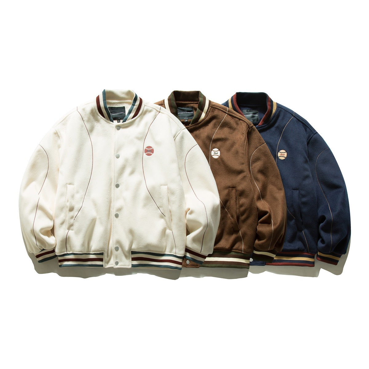 Three button-front varsity jackets in ivory, brown, and navy, with striped ribbing and small chest emblems.