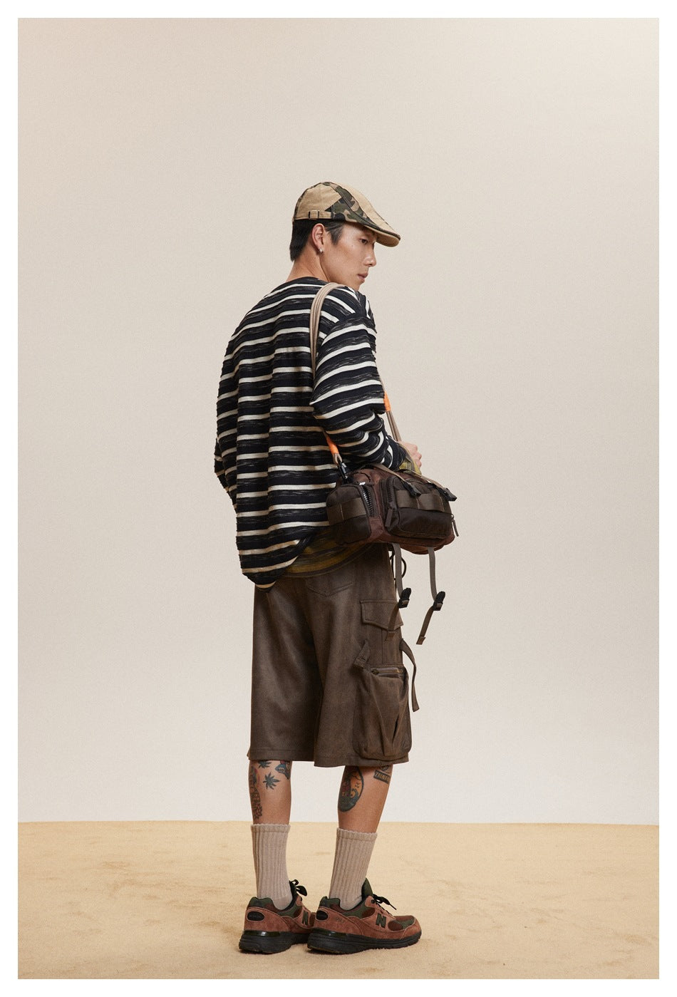 Rear three-quarter view of a model wearing a black-and-cream striped shirt and brown cargo shorts.
