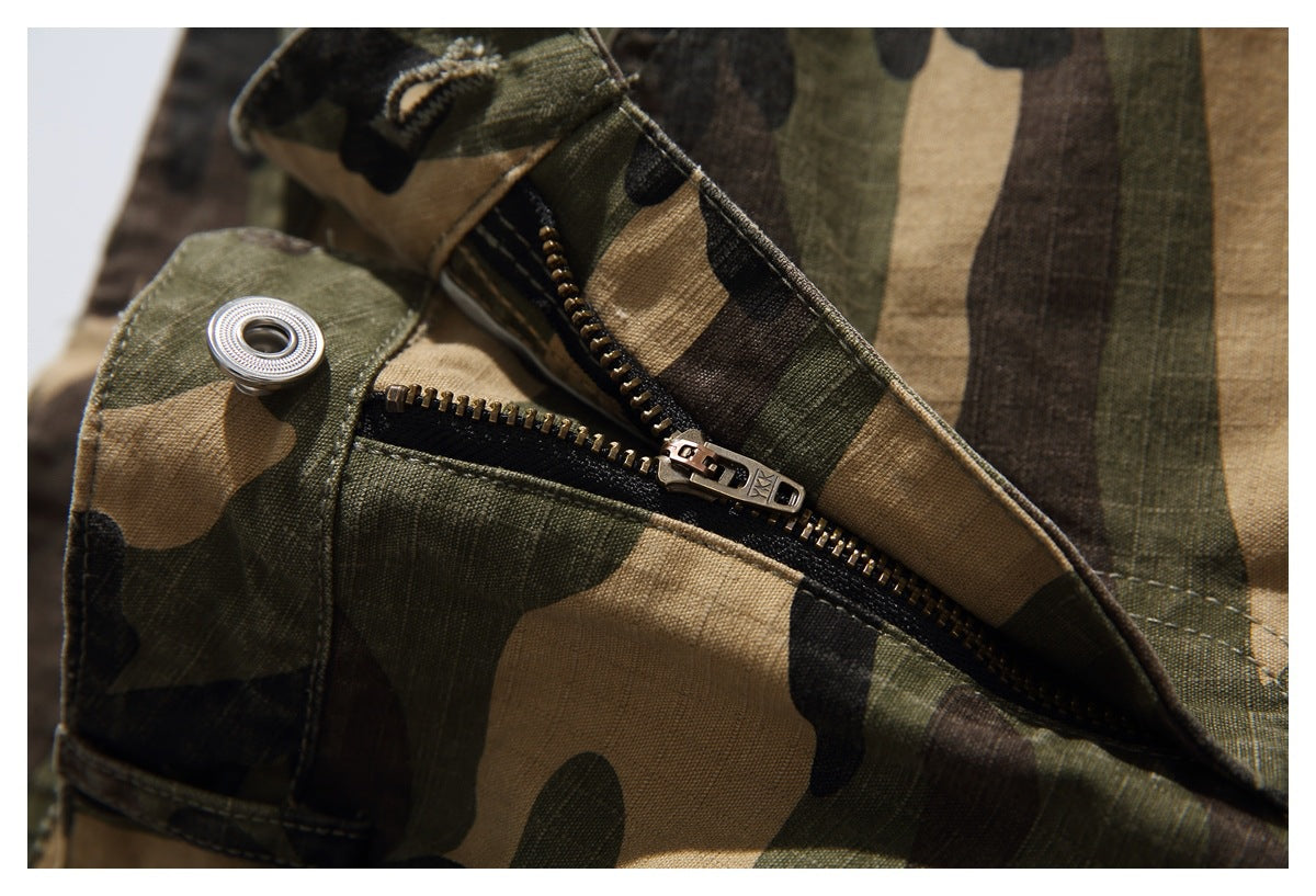 Close-up of the camouflage trousers' metal zipper and waistband button.