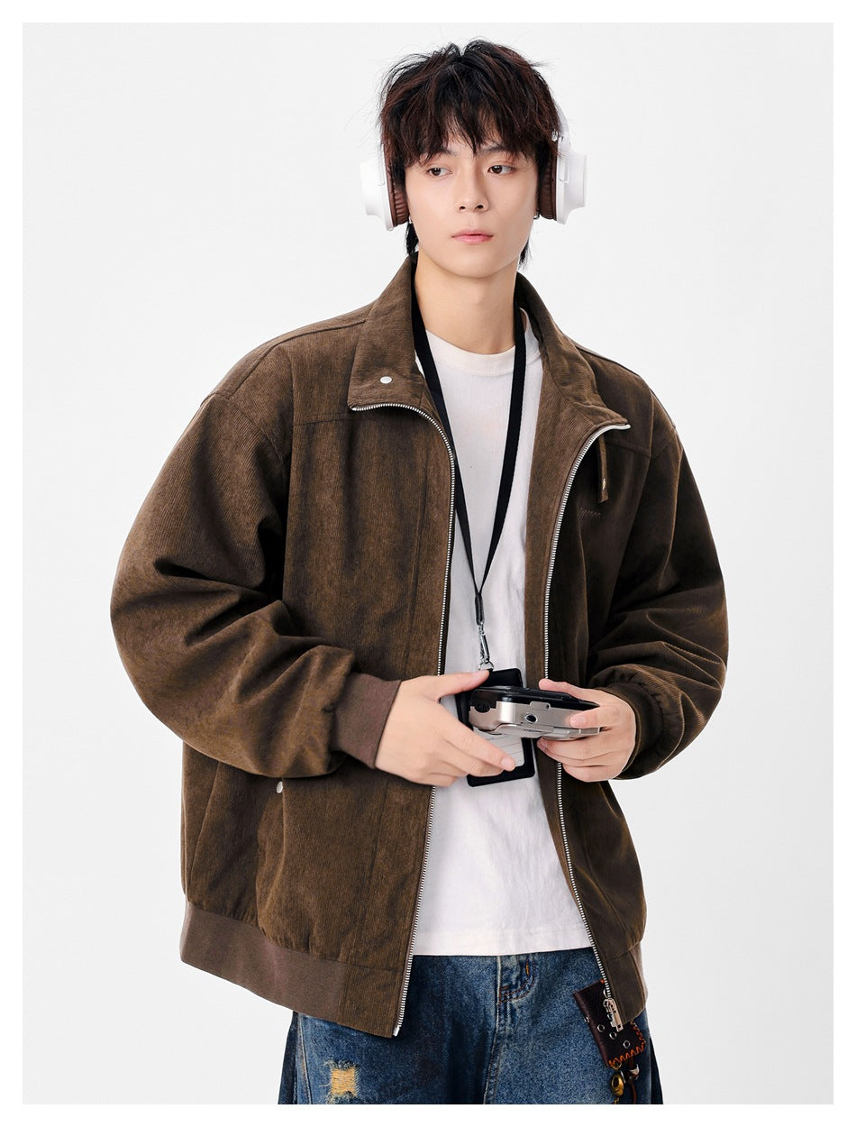 Model wearing an open dark brown zip-front jacket with a stand collar, ribbed trim, and small chest embroidery.