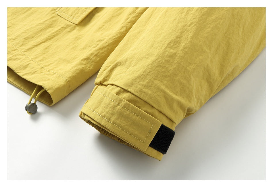 Close-up of a mustard-yellow jacket sleeve cuff with an adjustable hook-and-loop tab.