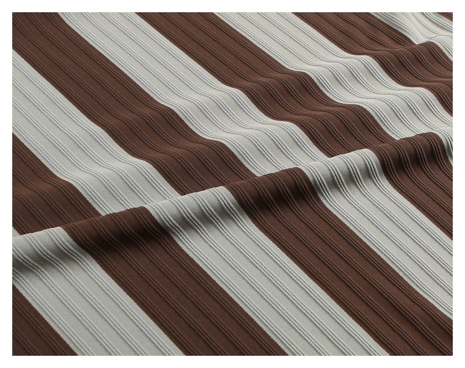 Close-up of brown and light gray fabric with broad diagonal stripes and raised ribbed texture, draped in folds.