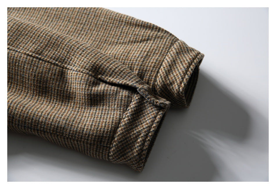 Close-up of a folded sleeve cuff and checked fabric on the brown coat.