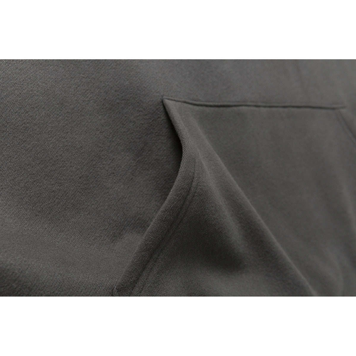 Close-up of charcoal sweatshirt fabric and a stitched pocket opening.