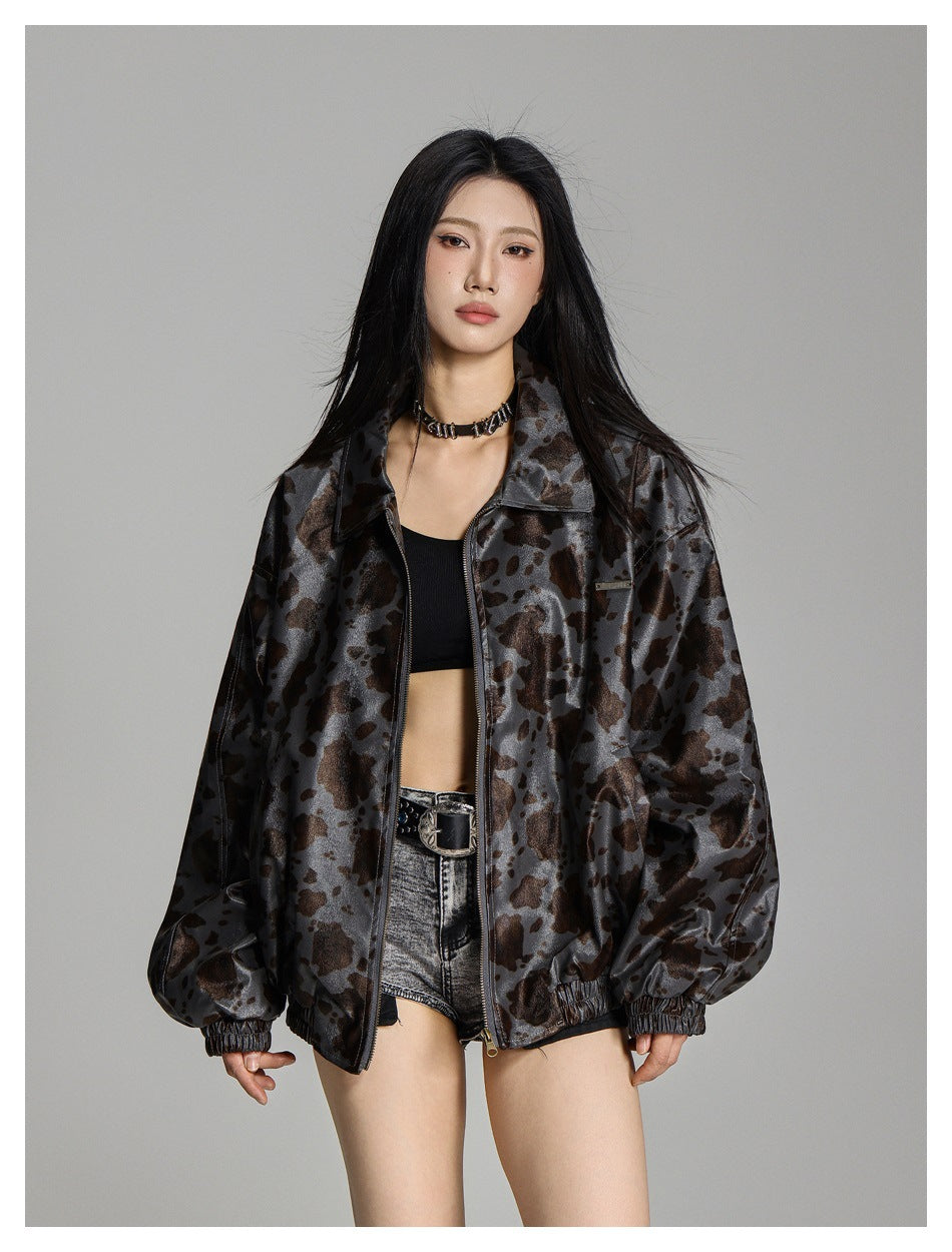 Model wearing a gray jacket with a brown and black irregular print, front zip, collar and elastic cuffs.