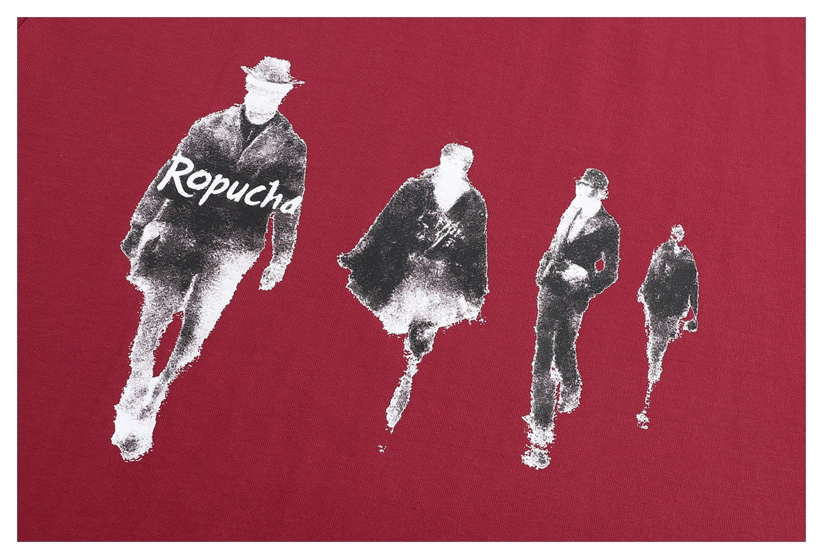 Close-up of burgundy fabric with a white and black print of four fashion figures and the word “Ropucha.”