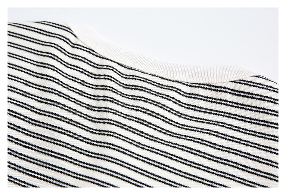 Close-up of the ribbed crew neckline on a black-and-off-white striped garment.