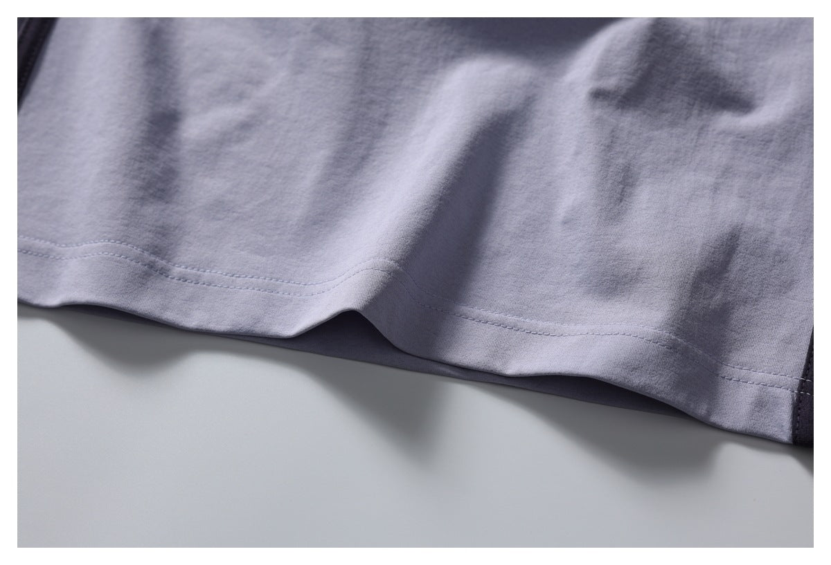 Close-up of the light gray shirt's stitched bottom hem and fabric.