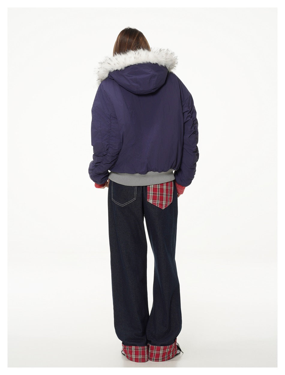 Back view of model wearing a navy fur-trimmed jacket and dark jeans with red plaid pocket and cuff accents.