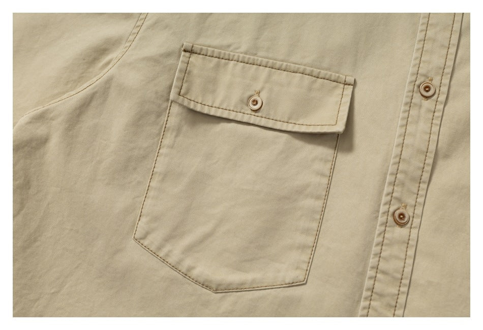 Close-up of the beige shirt’s button-flap chest pocket and front placket.