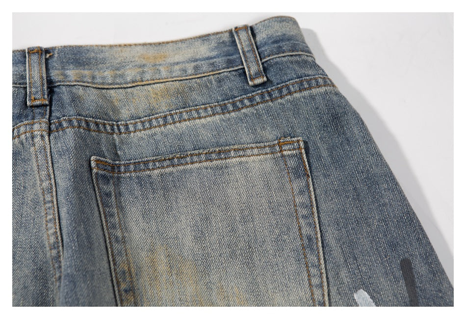 Close-up of a rear patch pocket and waistband on faded blue jeans.