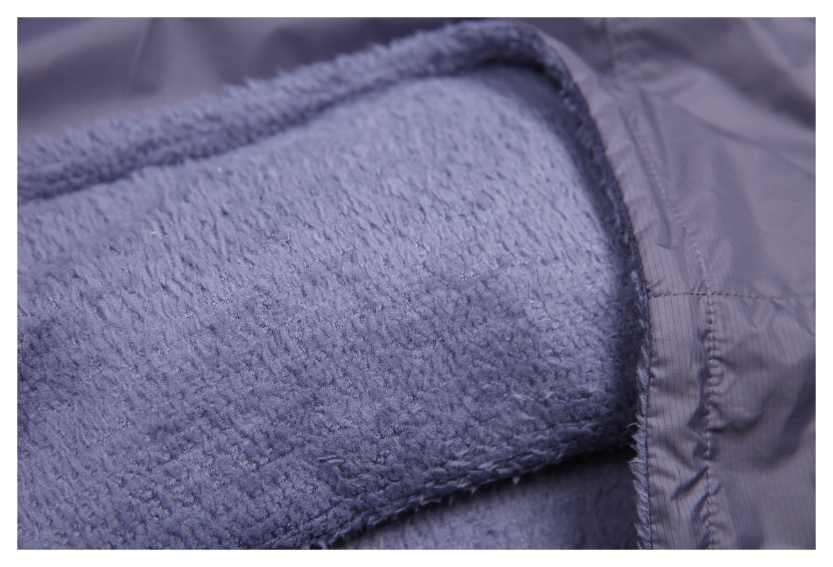 Close-up of the vest's soft lavender-gray fleece lining beside a stitched shell seam.
