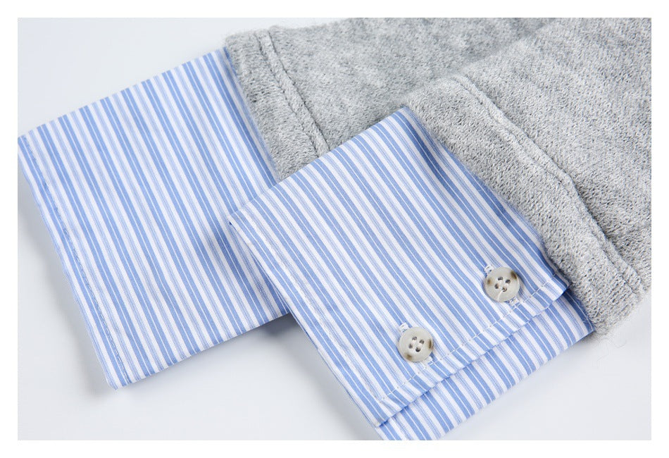 Close-up of a gray knit garment with a blue-and-white striped cuff and two buttons.