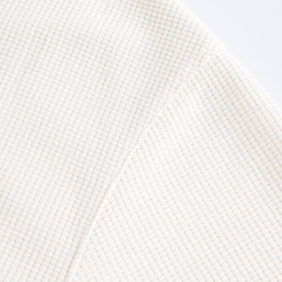 Close-up of the white shirt's small waffle-like surface texture.