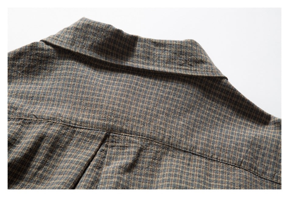 Close-up of the checked garment's collar and back yoke seam.