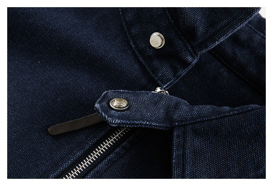 Close-up of a snap-fastening collar tab and silver zipper on a navy garment.