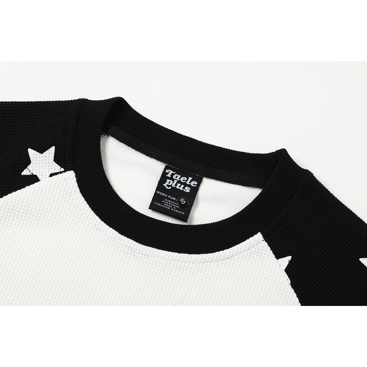 Close-up of the black ribbed crew neck and white front panel of a shirt, showing its sewn-in label.