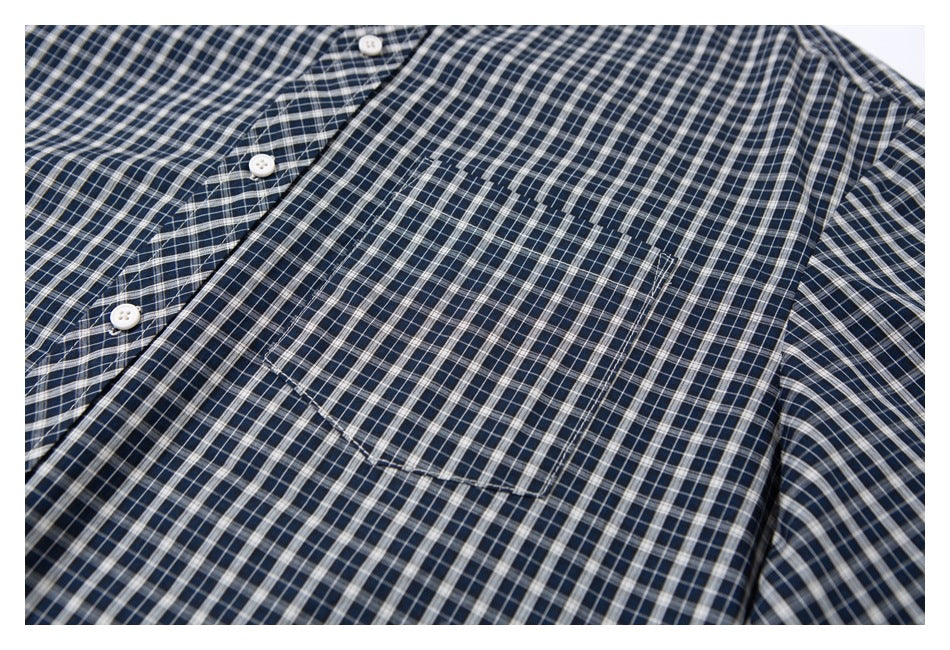 Close-up of a navy checked shirt showing its button placket and chest pocket.
