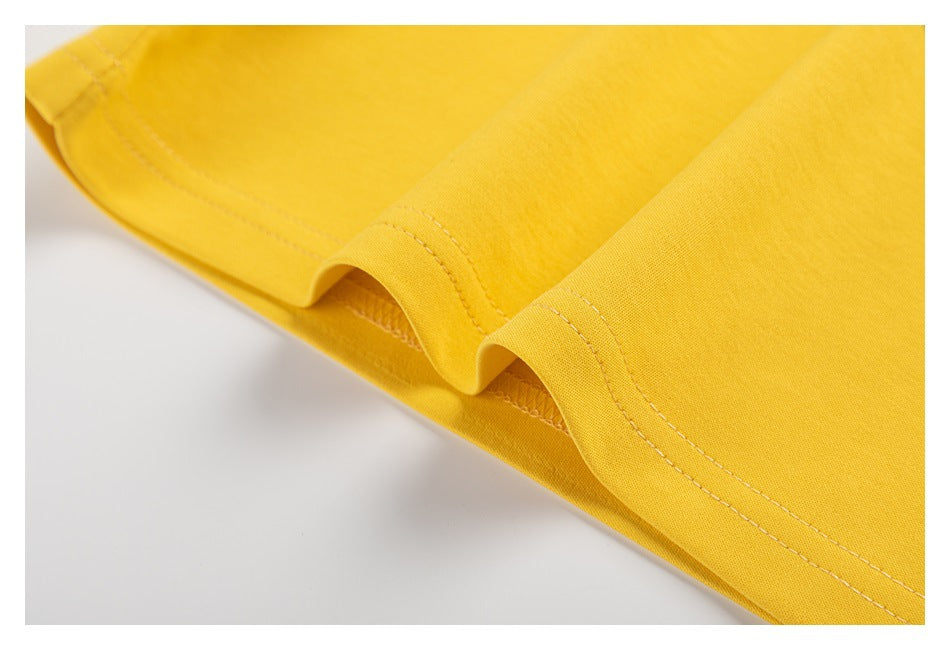Close-up of the yellow shirt's stitched hem and fabric edge.