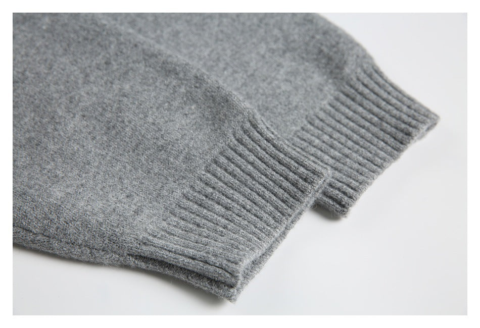 Close-up of a ribbed cuff on the heather gray knit garment.