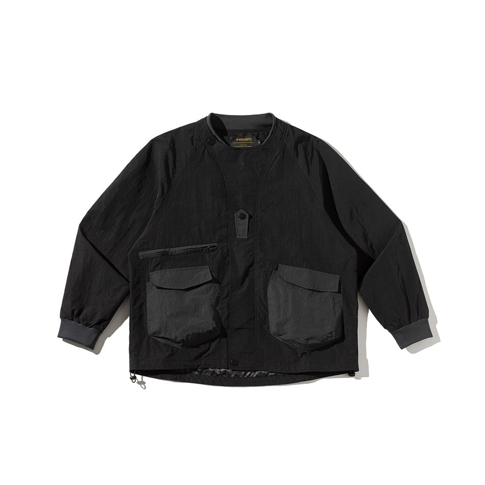 Black utility jacket flat lay, front view, with ribbed collar, two large flap pockets and chest zip pocket