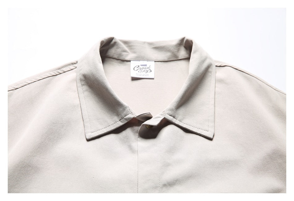 Close-up of a light beige shirt collar with a small woven neck label.