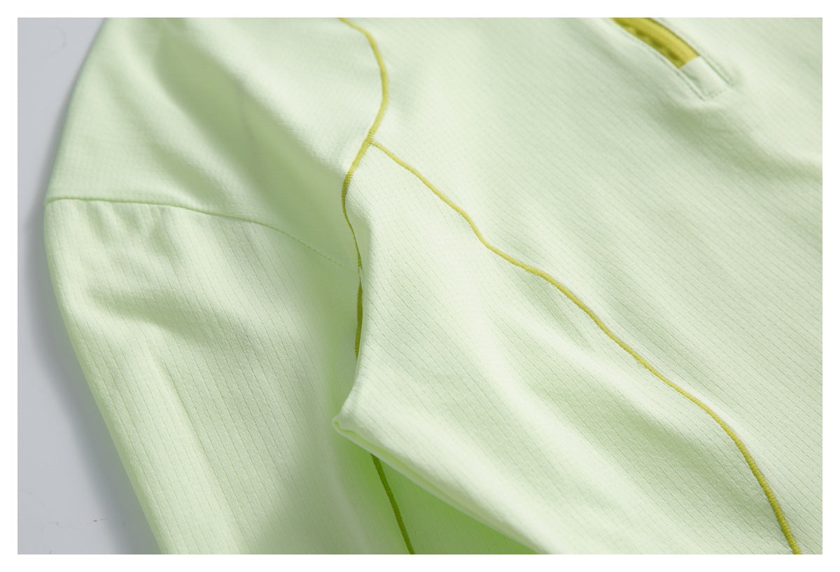 Close-up of pale lime fabric with curved yellow piping and part of the zipper.