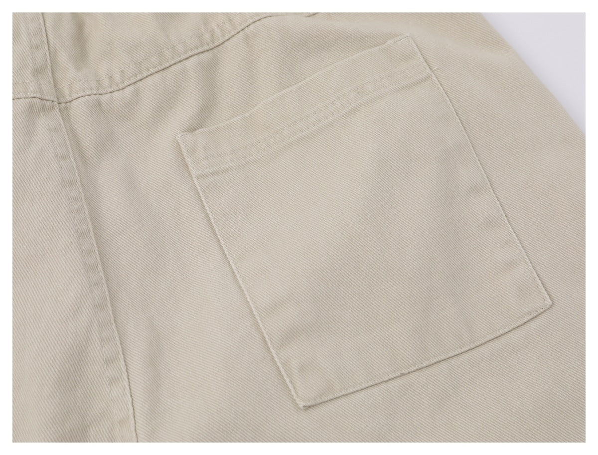 Close-up of a large rectangular patch pocket on beige trousers.