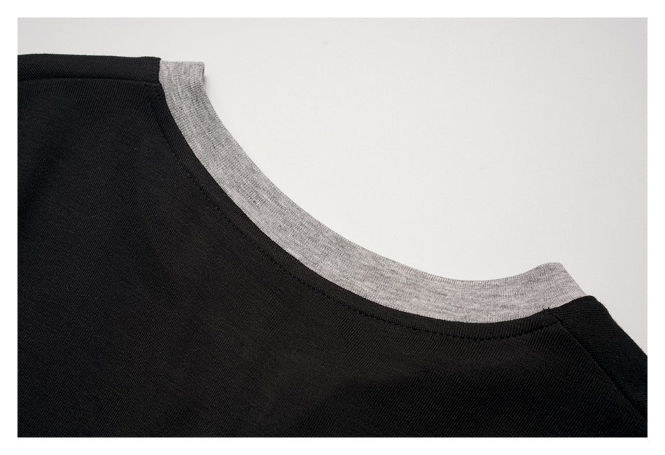 Close-up of a black garment neckline edged with heather-gray ribbed trim.