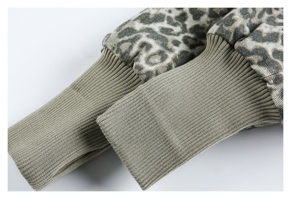 Close-up of ribbed gray-green cuffs on a jacket with a muted animal-print exterior.